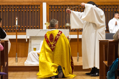 Father Poorman presiding at an adoration service