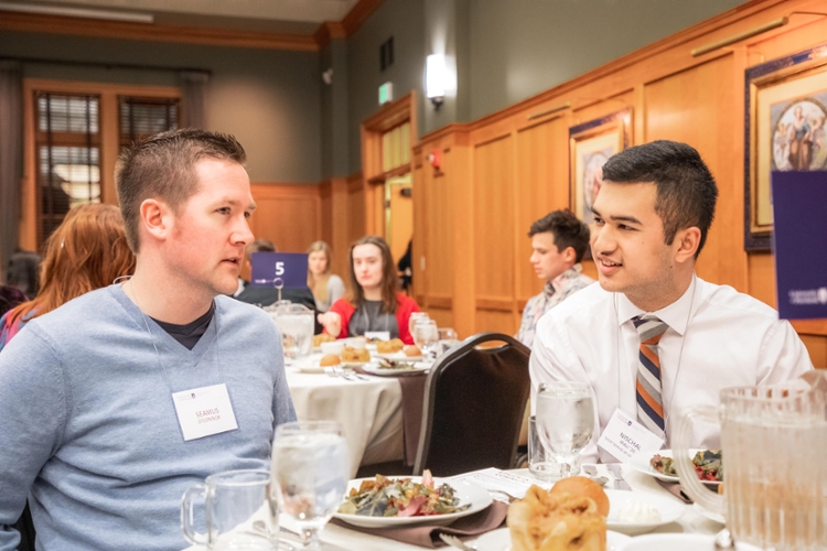 guest speaker talking with students at table