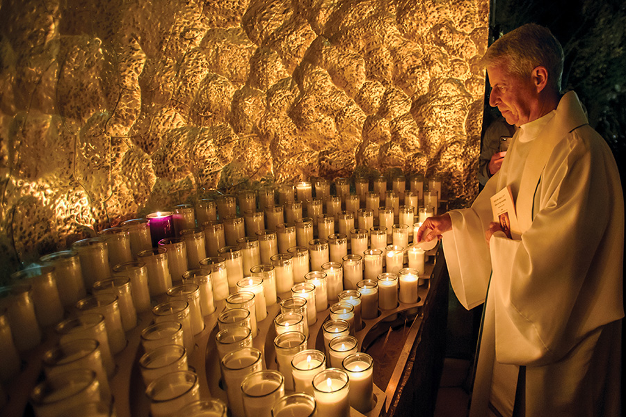 Father Mark Poorman lighting a candle
