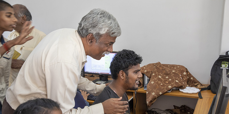 photo of man teaching on computer