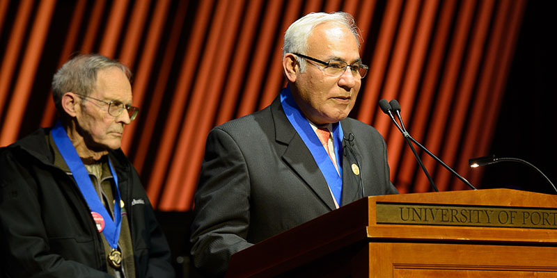 José Antonio Patrón Quispe and Rev. Daniel Panchot speaking on stage at podium
