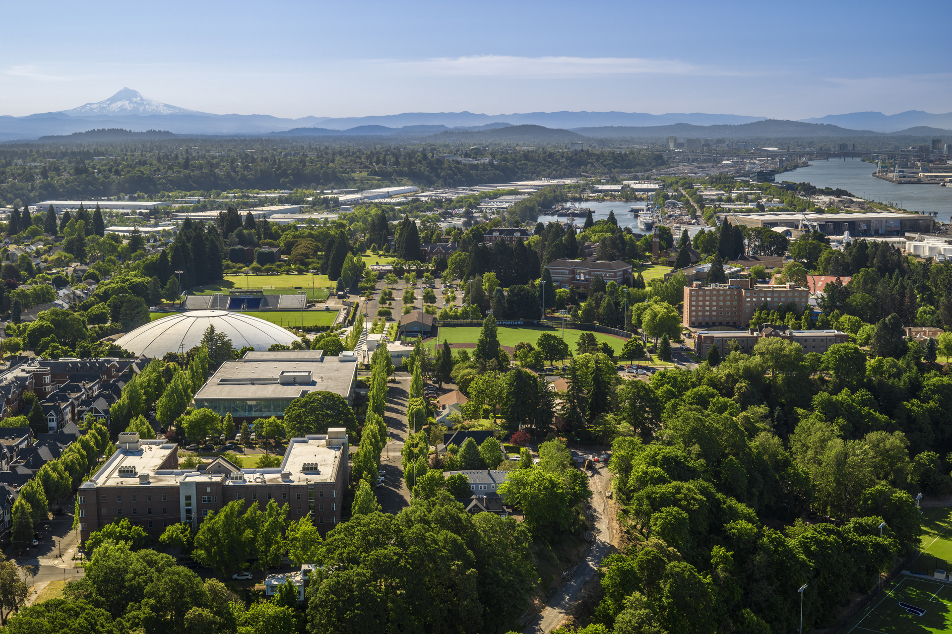 An aerial image of The Bluff, a nick name for the UP campus, on a clear day with the northwest landscape in the background.