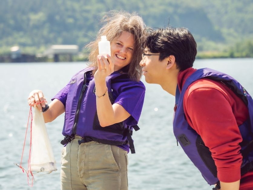 Teacher and student studying algae blooms on the river campus.