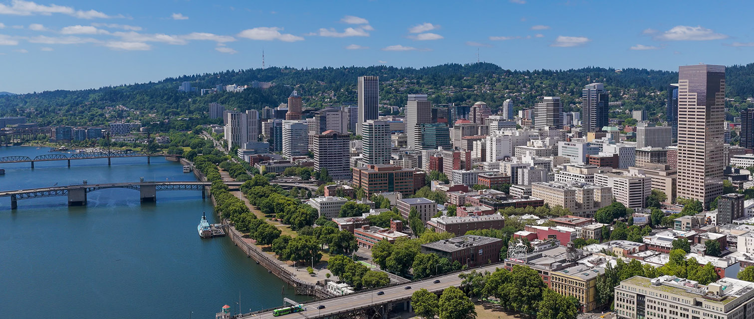 Aerial view of downtown Portland from over the river with Council Crest in the far background.