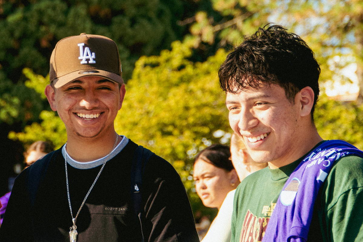 A close-up view of two University of Portland students smiling outdoors during an Activities Fair.