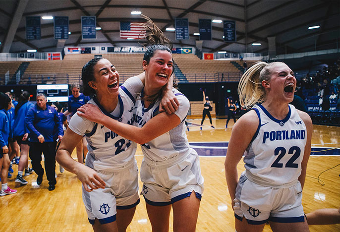 University of Portland's women's basketball team members celebrating