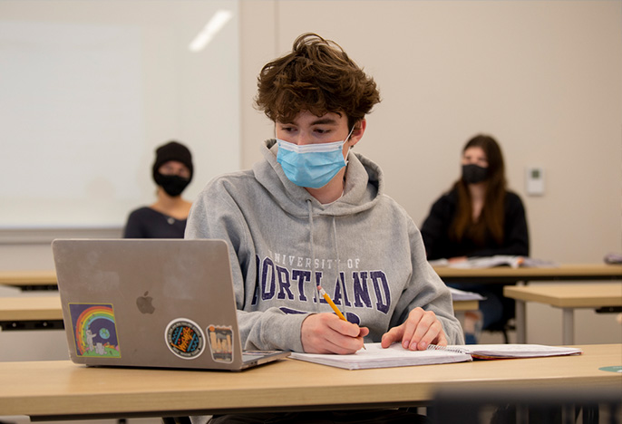 Student in a classroom following safety protocols