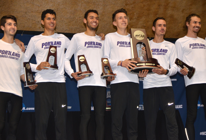Pilot men's X-country team holding trophies on the awards stage.