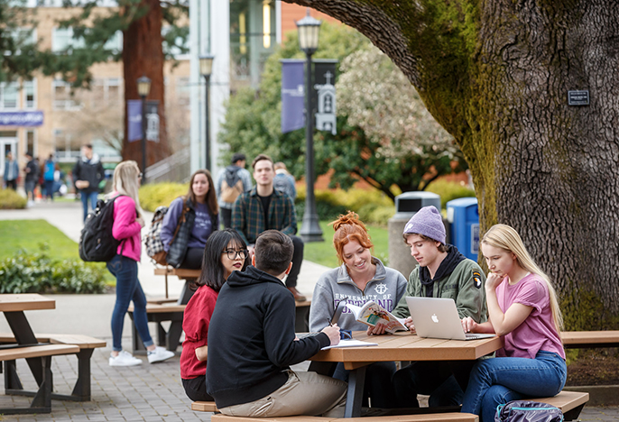 University of Portland students sitting outside at table