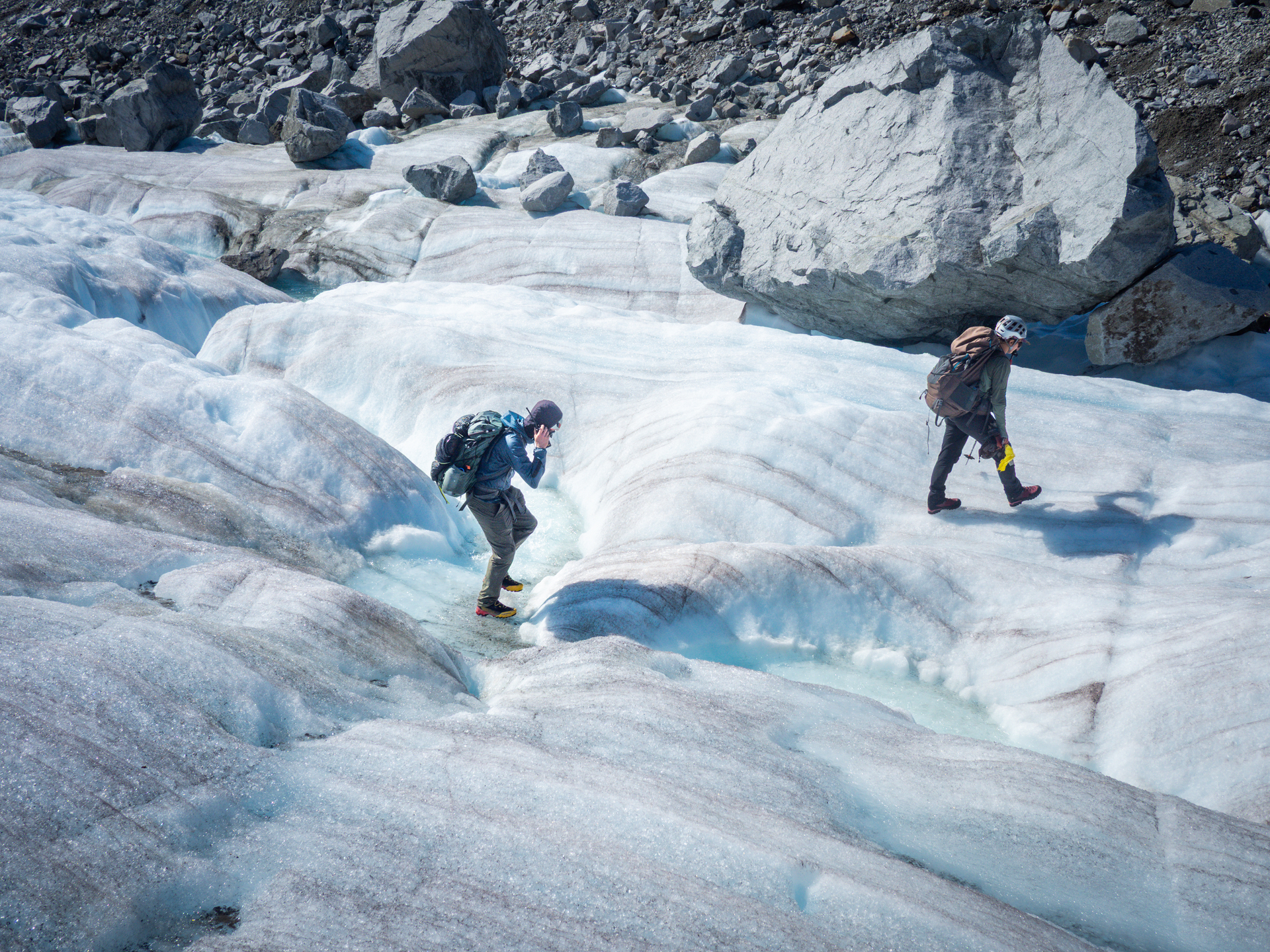 UP student researchers, seen from above, trek over the blue ice of a glacier during field research.