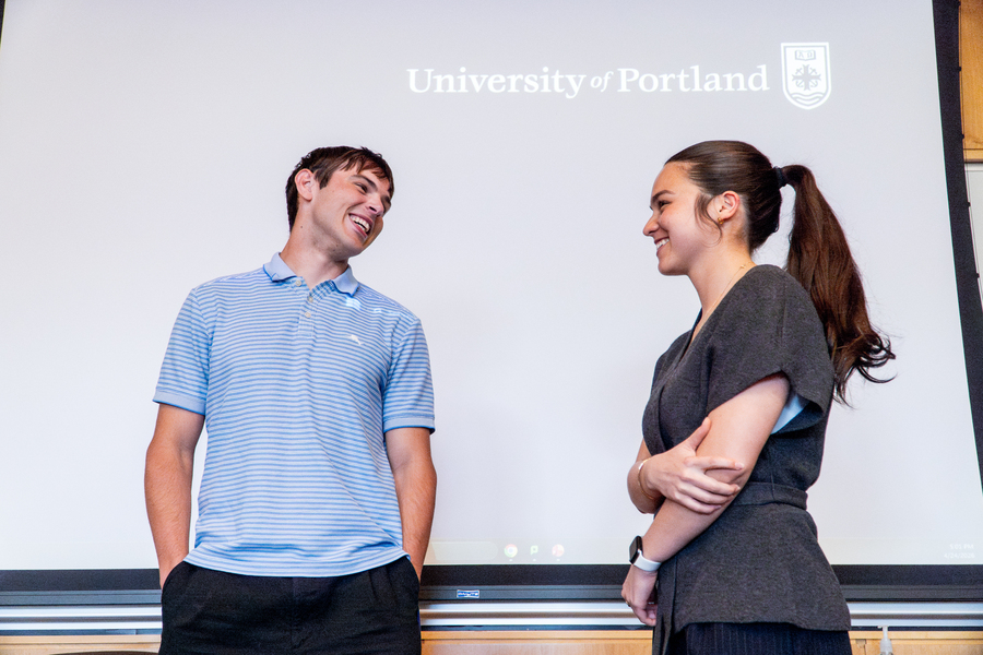 Two students smiling at one another after a presentation.