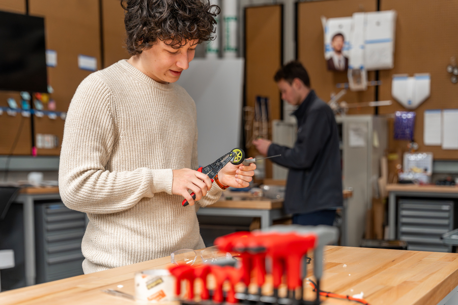 An engineering student works with equipment in the design lab.