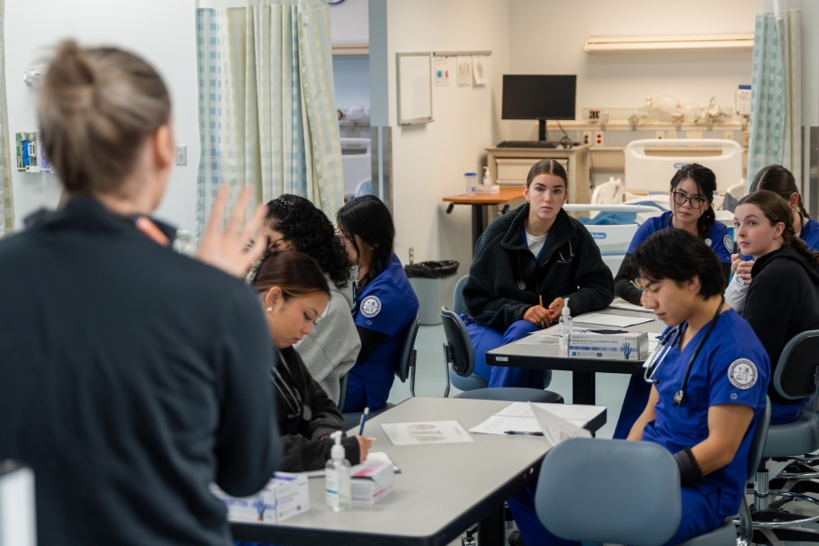 UP students getting guidance from an instructor in UP's nursing sim lab.