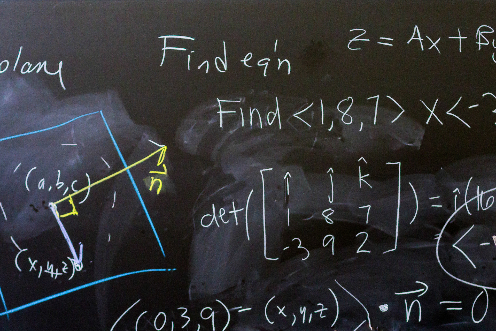 An image of a chalkboard covered in mathematical equations written with colorful chalk at the University of Portland.