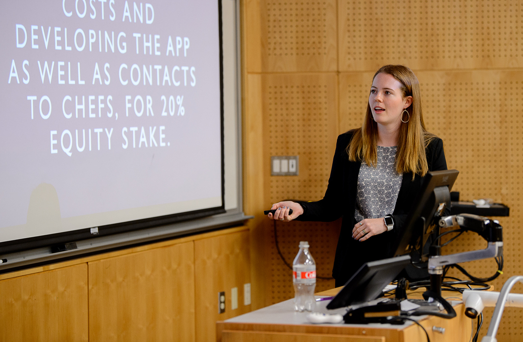 A business administration student presents their research in front of a digital projector screen during an innovation class at the University of Portland.