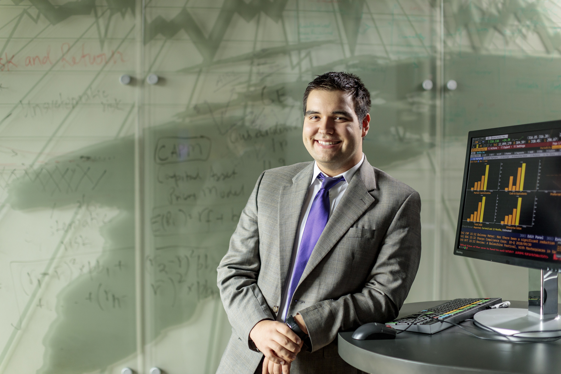An economics student stands next to a a computer terminal in UP's Bloomberg Research Lab.