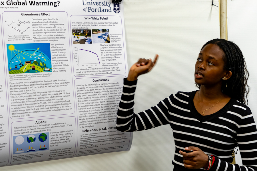A close-up of a printed page shows a colorful infographic of the greenhouse effect above scientific text discussing radiative forcing, greenhouse gases, and temperature calculations.