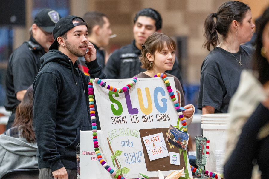 Two University of Portland students stand at an informational table for the Student Led Unity Garden at the student activities fair.