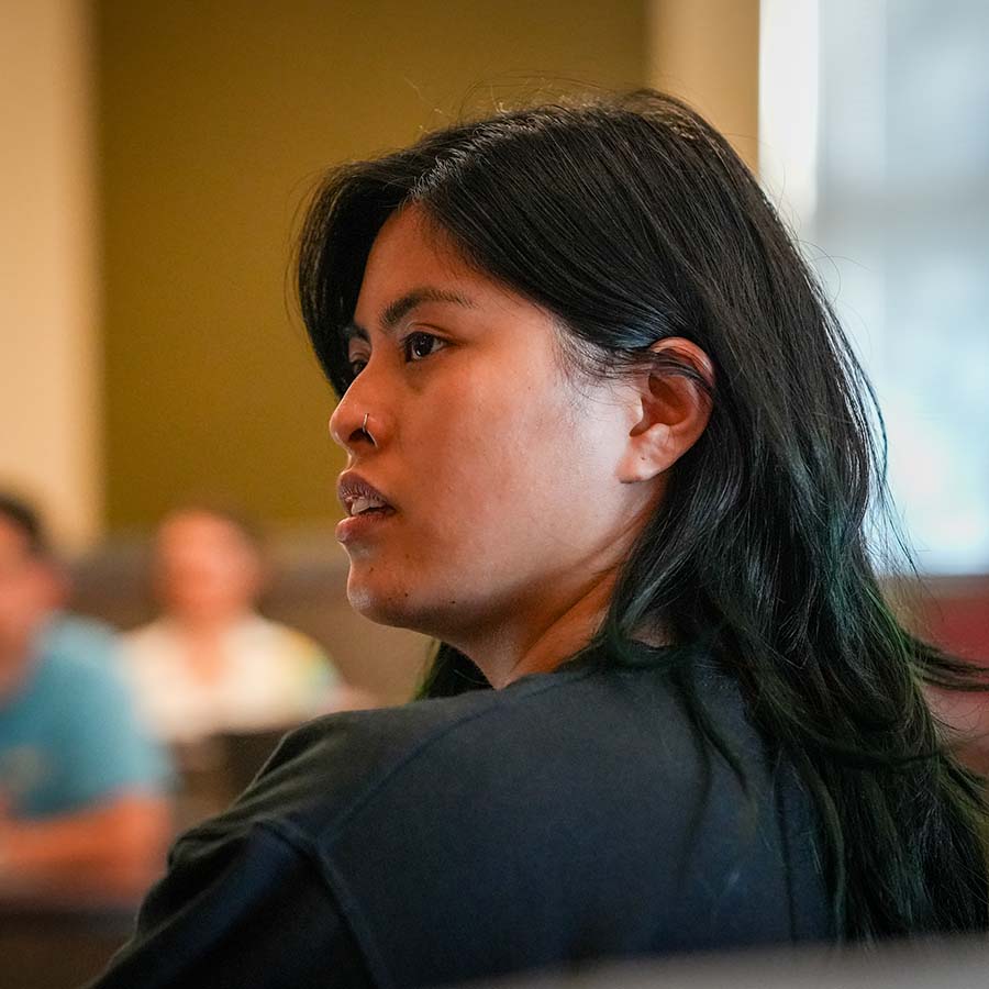A University of Portland student listens intently during a business class with two other students in the background
