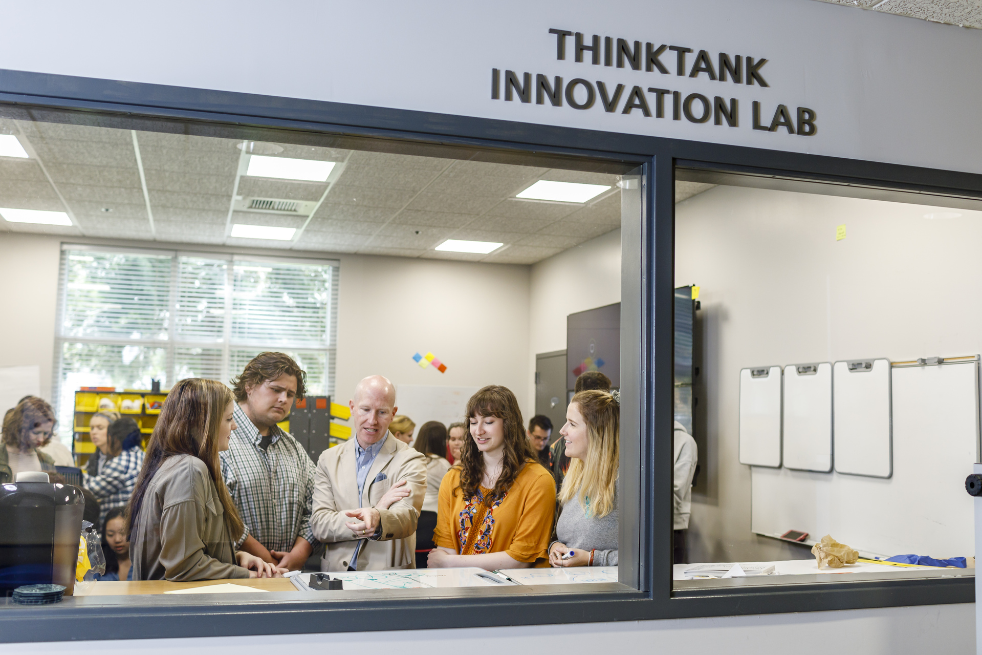 Students work with their professor in the Innovation Lab workspace at the University of Portland.