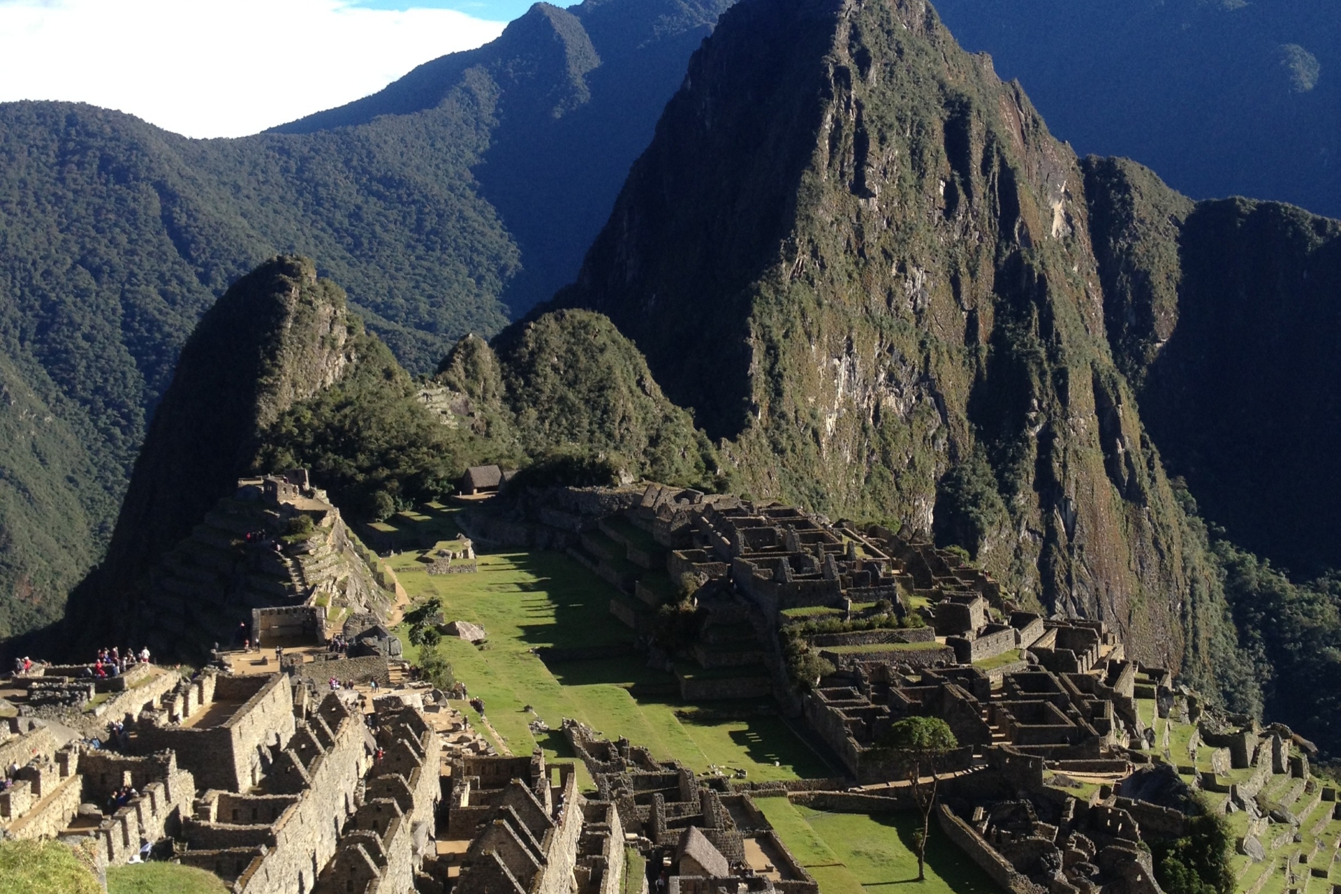 An aerial image of Macchu Picchu and the surrounding green hills.