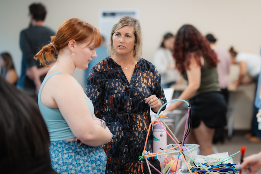 A University of Portland education student and professor converse over a project in a social and emotional learning course.