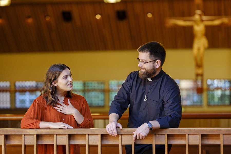 A University of Portland student and Fr Gallagher talk in the Chapel of Christ the Teacher