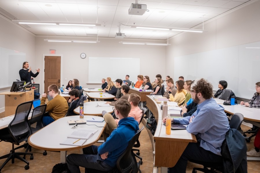 A bright modern classroom filled with students listens to a lecture being given by a History professor at the University of Portland.