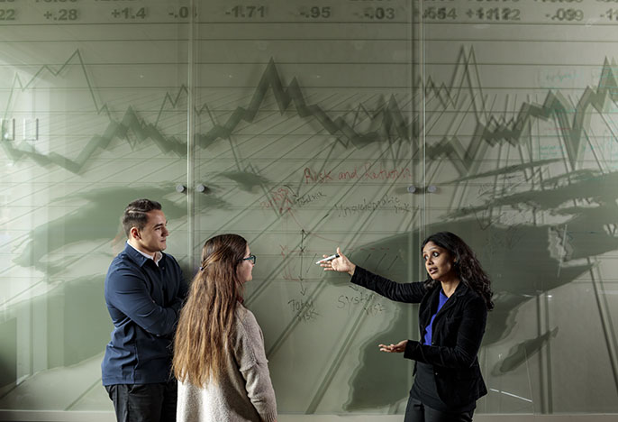 Business professor teaching two students
