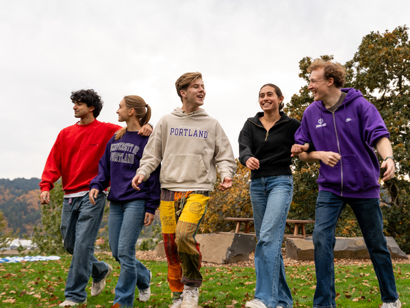 Five UP students walk along The Bluff while chatting casually 