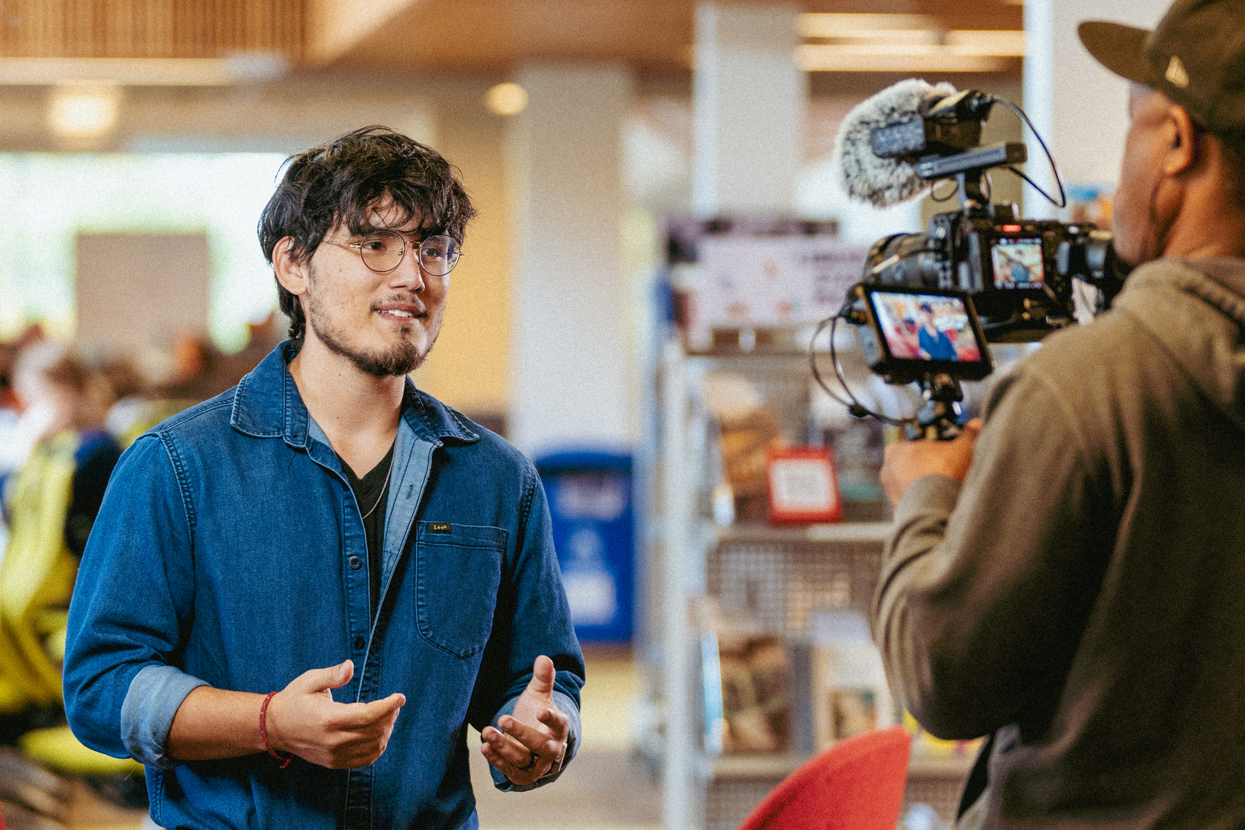 Israel Oscorio, a UP student, looks directly at a video camera, filming an interview for UP's The College Tour episode.