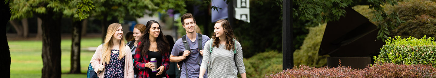 A group of new students walk a path on the University of Portland campus