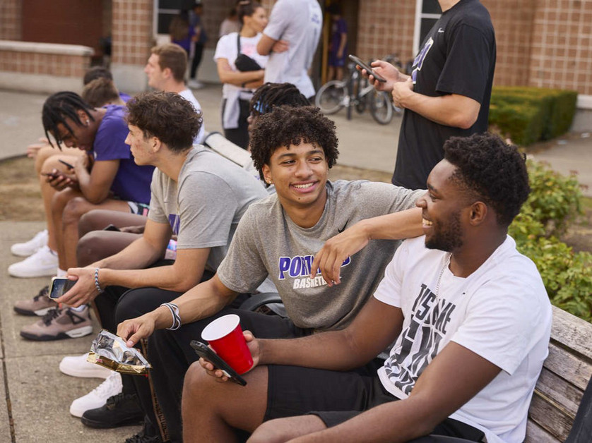 students sitting by dorm