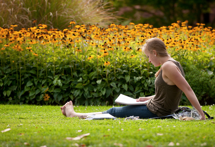 girl studying in the grass