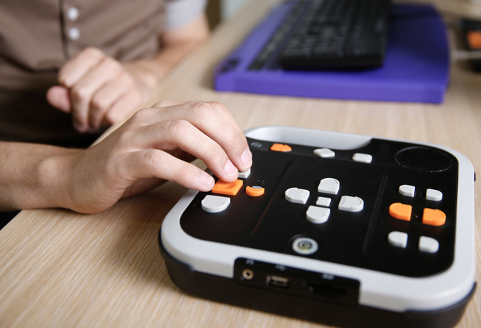 Blind student operates audio reader.