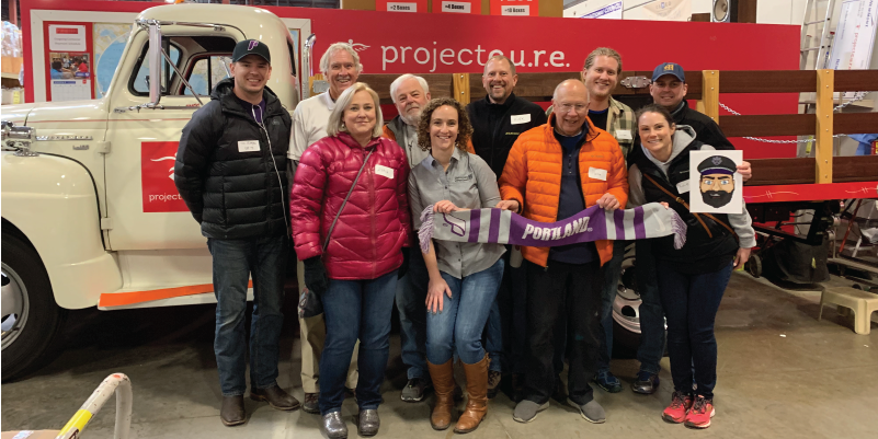 Alumni standing in front of a truck after volunteering at Project Cure.