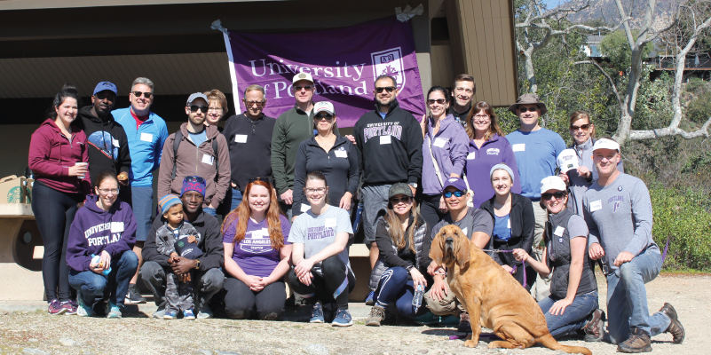 Alumni and a dog ready to go on a hike