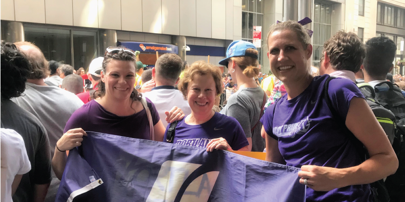 Alumni holding a UP flag at a parade in New York.