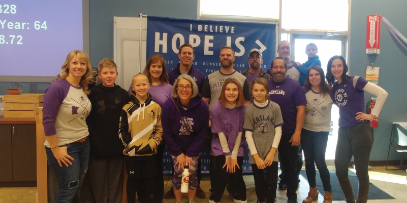 Alumni and their families posing for a picture after volunteering.