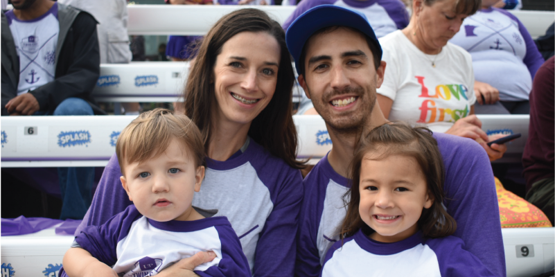A couple and their two kids in purple and white for a Saints game
