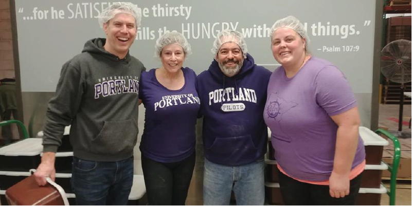 Four alumni rocking some hairnets after volunteering at a food bank.