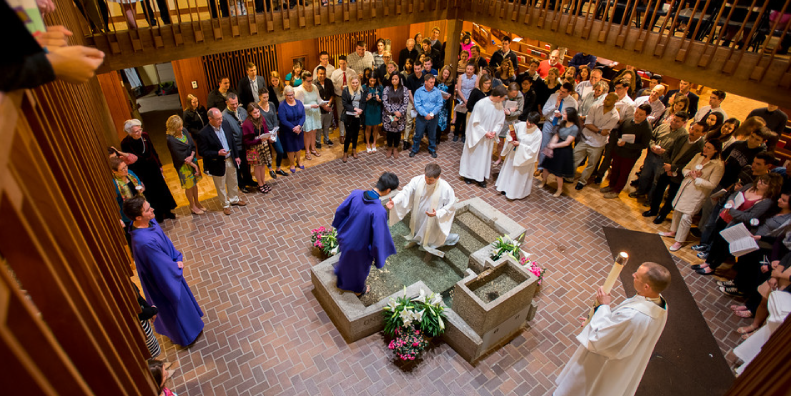 Congregation watching a baptism in the Chapel of Christ the Teacher