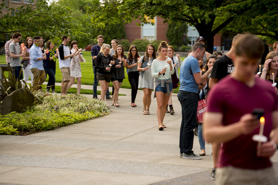 students with lighted candles at outdoor prayer service