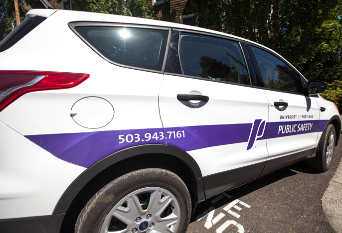 side of a campus safety car. Large white SUV with large purple stripe on the side. 