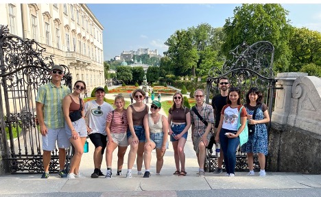 Salzburg faculty-led program of students and faculty pose for a photo in front of the Mirabell Gardens