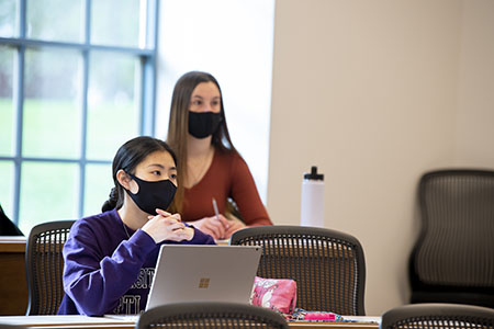 Two students at desks in classroom