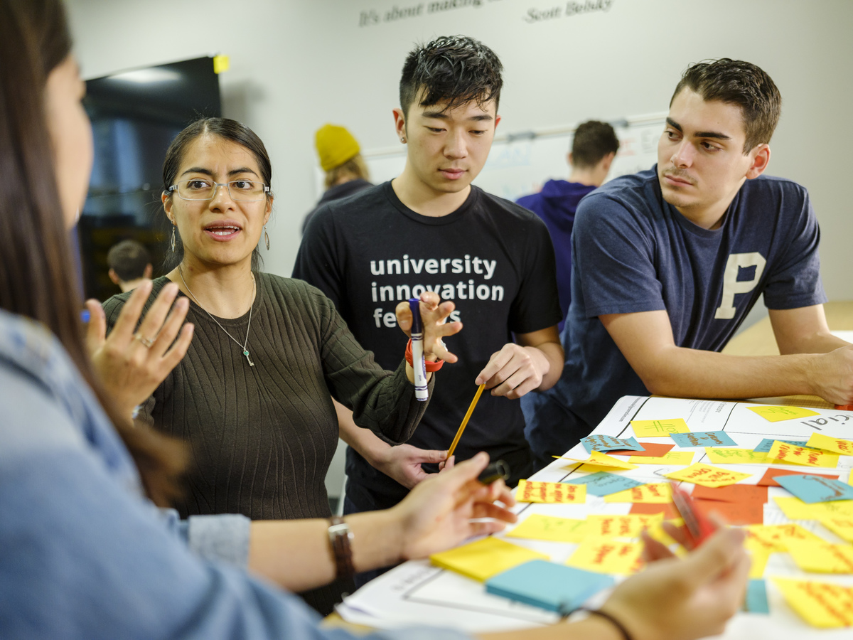 students listen to professor explain in innovation lab