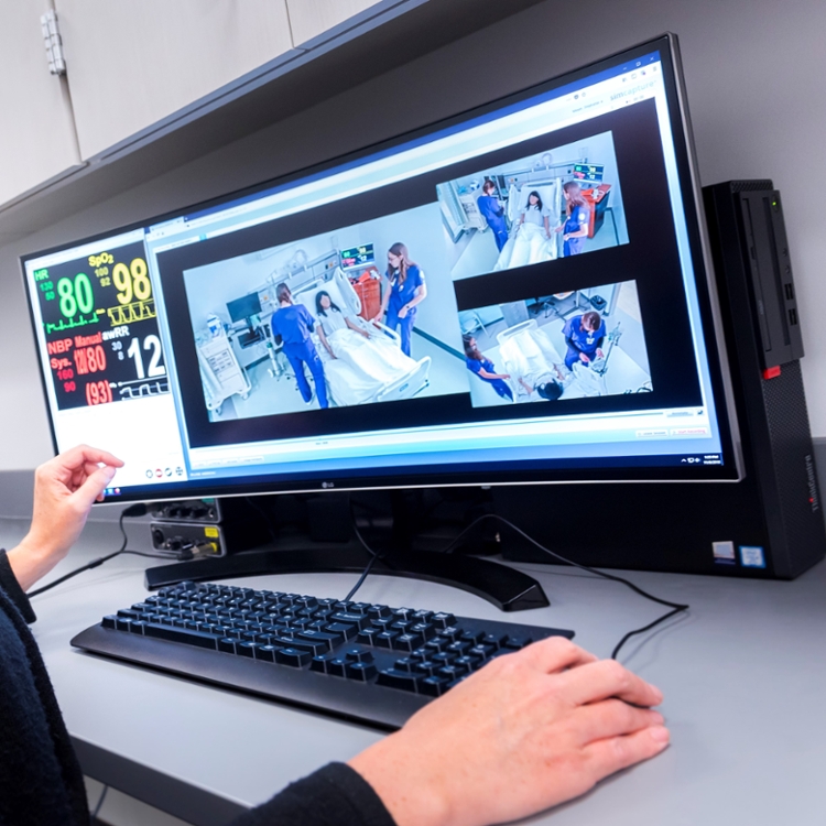 screen showing nursing students in bedside simulation lab.