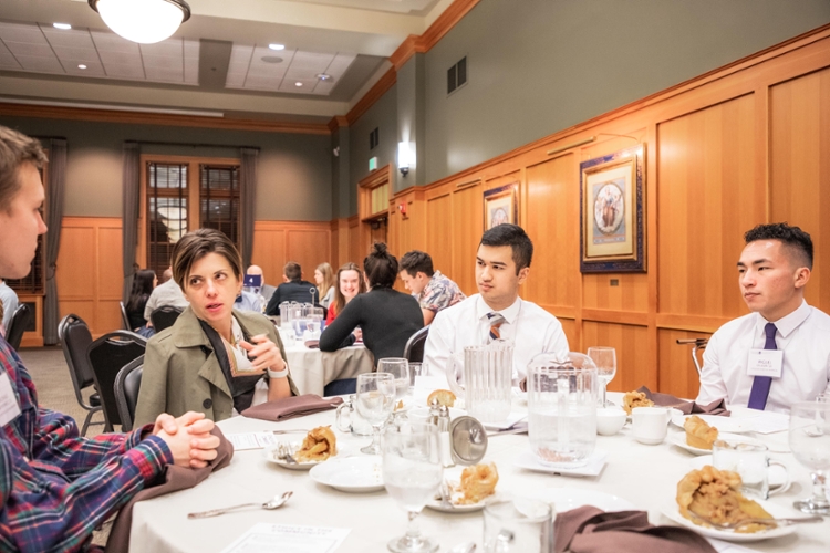 guest speaker talking with students at table