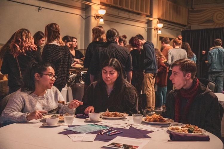 students conversing at table while eating